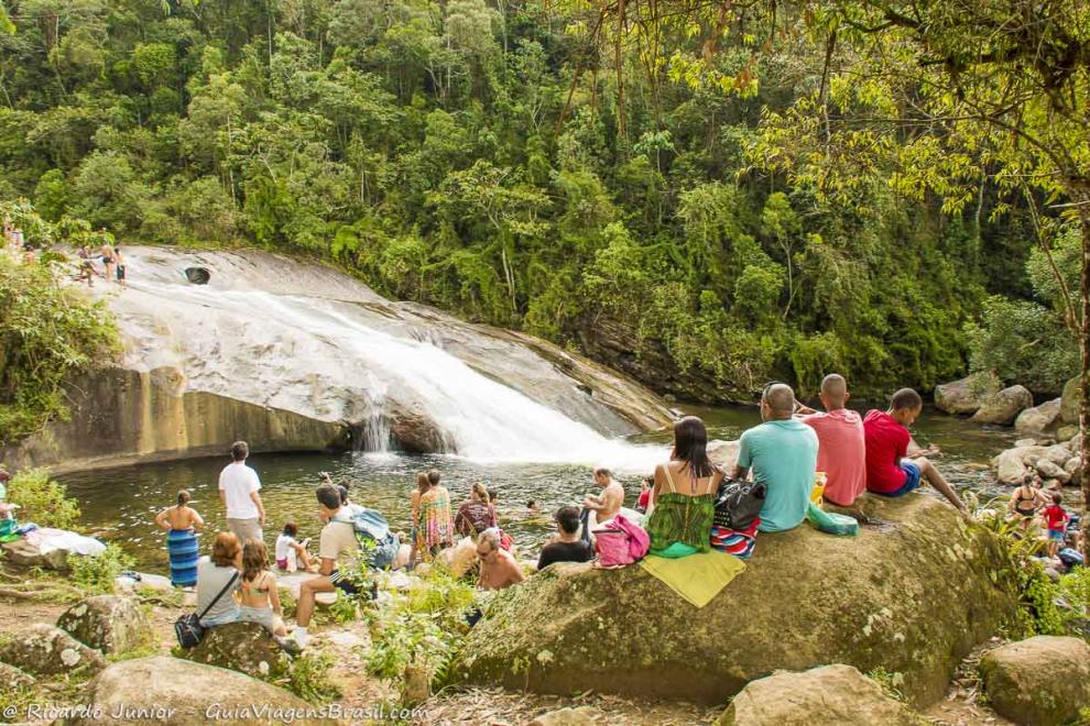 Imagem de turistas nas pedras da Cachoeira do Escorrega em Visconde de Mauá.